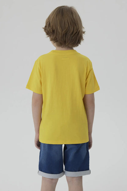 Polera amarilla de algodón con un Minion caricaturesco sosteniendo un lápiz, acompañado de un texto divertido en azul, ideal para fans de la saga Despicable Me.