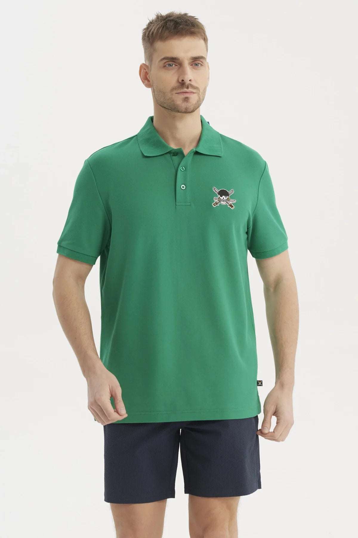 Polera Piqué verde con bordado de calavera pirata y espadas cruzadas, representando a los Sombreros de Paja de One Piece, ideal para aventuras en alta mar.