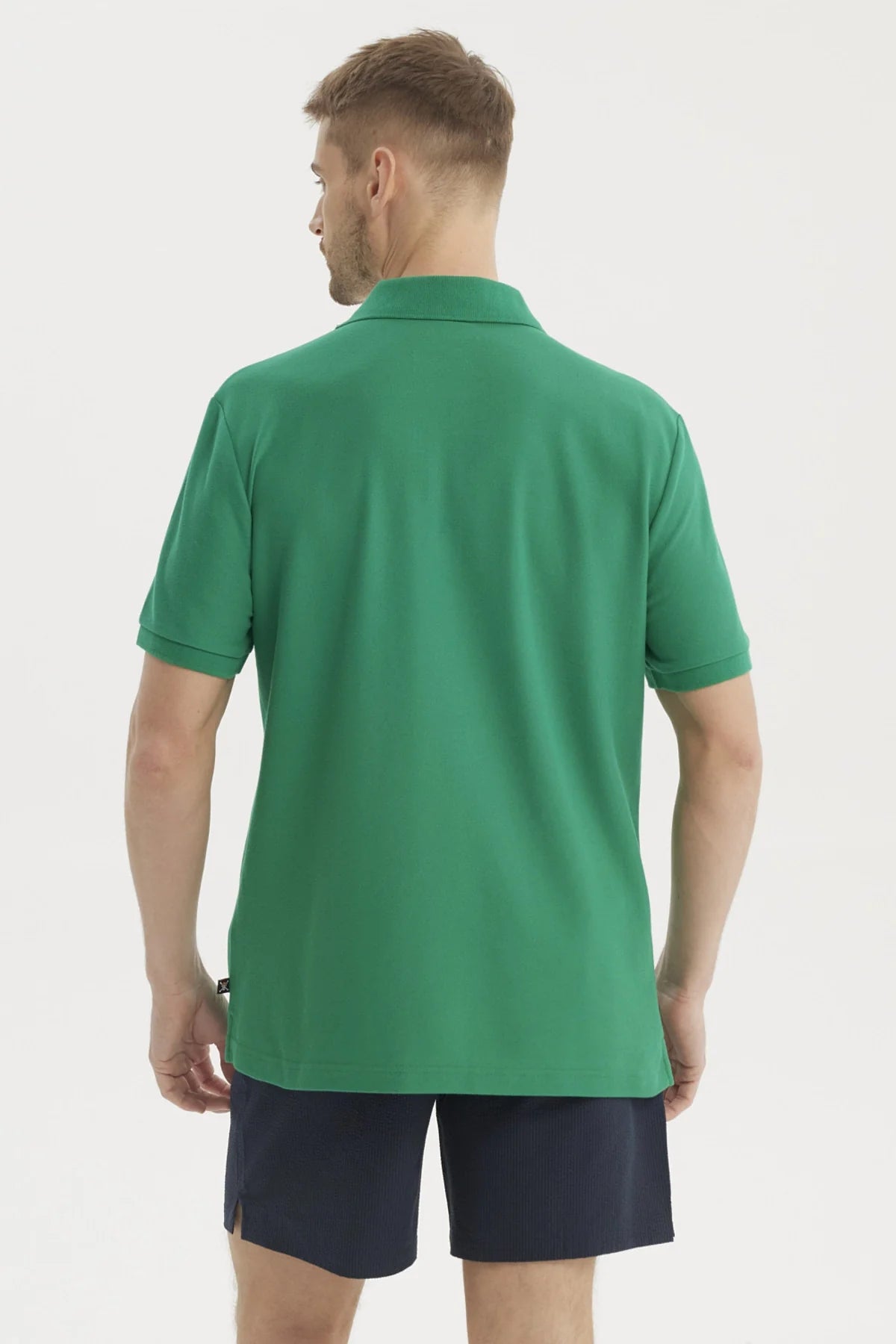 Polera Piqué verde con bordado de calavera pirata y espadas cruzadas, representando a los Sombreros de Paja de One Piece, ideal para aventuras en alta mar.