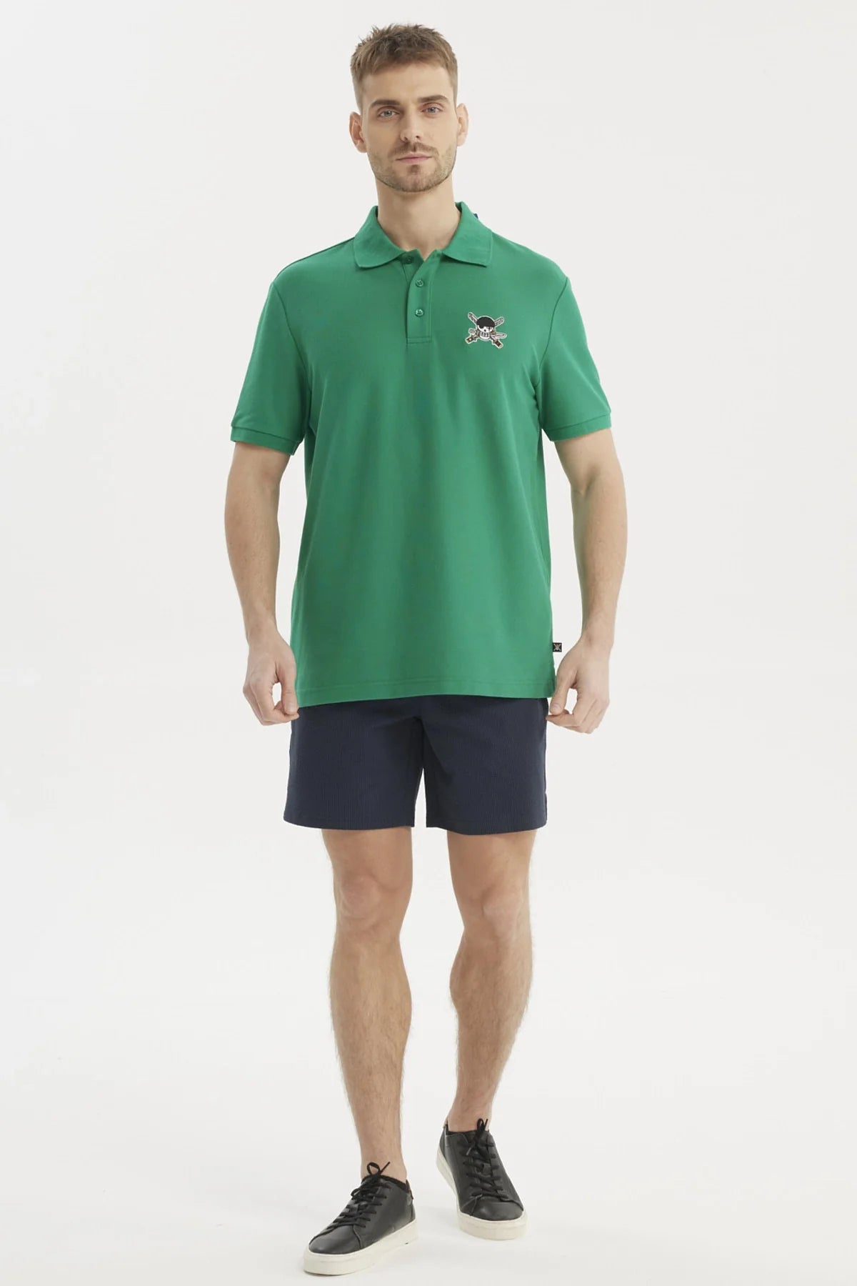Polera Piqué verde con bordado de calavera pirata y espadas cruzadas, representando a los Sombreros de Paja de One Piece, ideal para aventuras en alta mar.