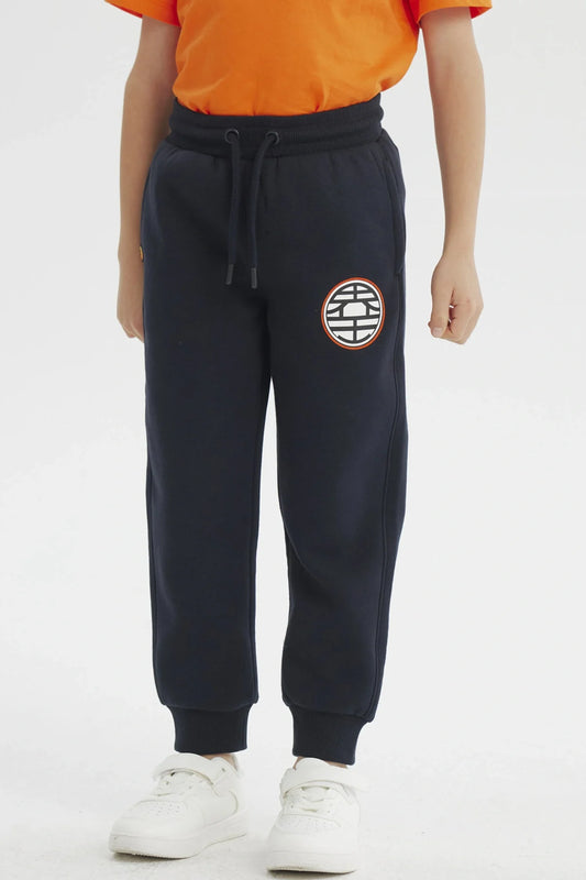 Pantalón buzo azul marino con el icónico emblema de la Tortuga Genial en el muslo, ideal para fans de Dragon Ball Z, perfecto para aventuras cotidianas.