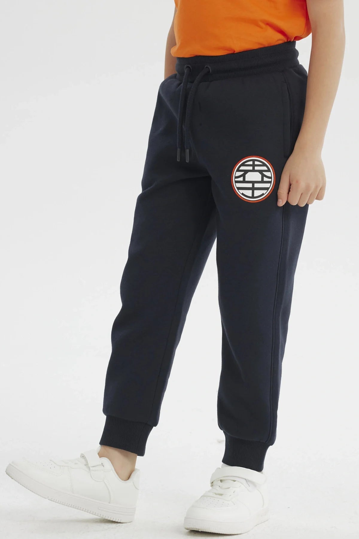 Pantalón buzo azul marino con el icónico emblema de la Tortuga Genial en el muslo, ideal para fans de Dragon Ball Z, perfecto para aventuras cotidianas.
