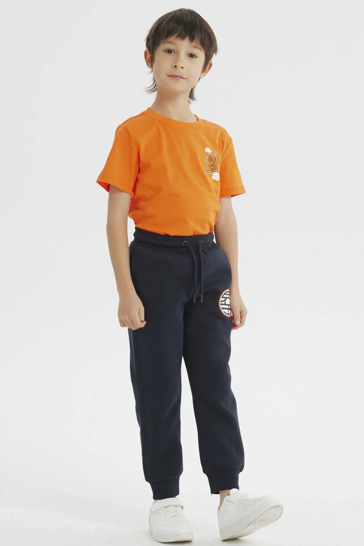 Pantalón buzo azul marino con el icónico emblema de la Tortuga Genial en el muslo, ideal para fans de Dragon Ball Z, perfecto para aventuras cotidianas.