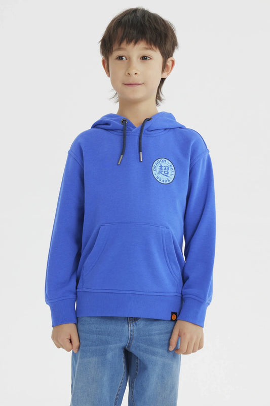 Polerón azul con capucha, presenta un logo circular de Dragon Ball en el pecho, ideal para los fans de Vegeta, combinando comodidad y estilo.