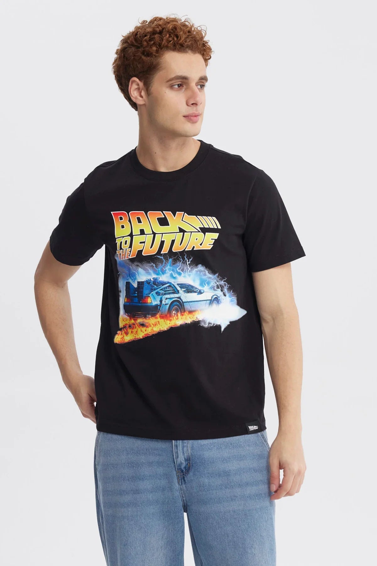 Polera negra de Back to the Future con un diseño vibrante que muestra el DeLorean rodeado de llamas y rayos, evocando la icónica saga de viajes en el tiempo.