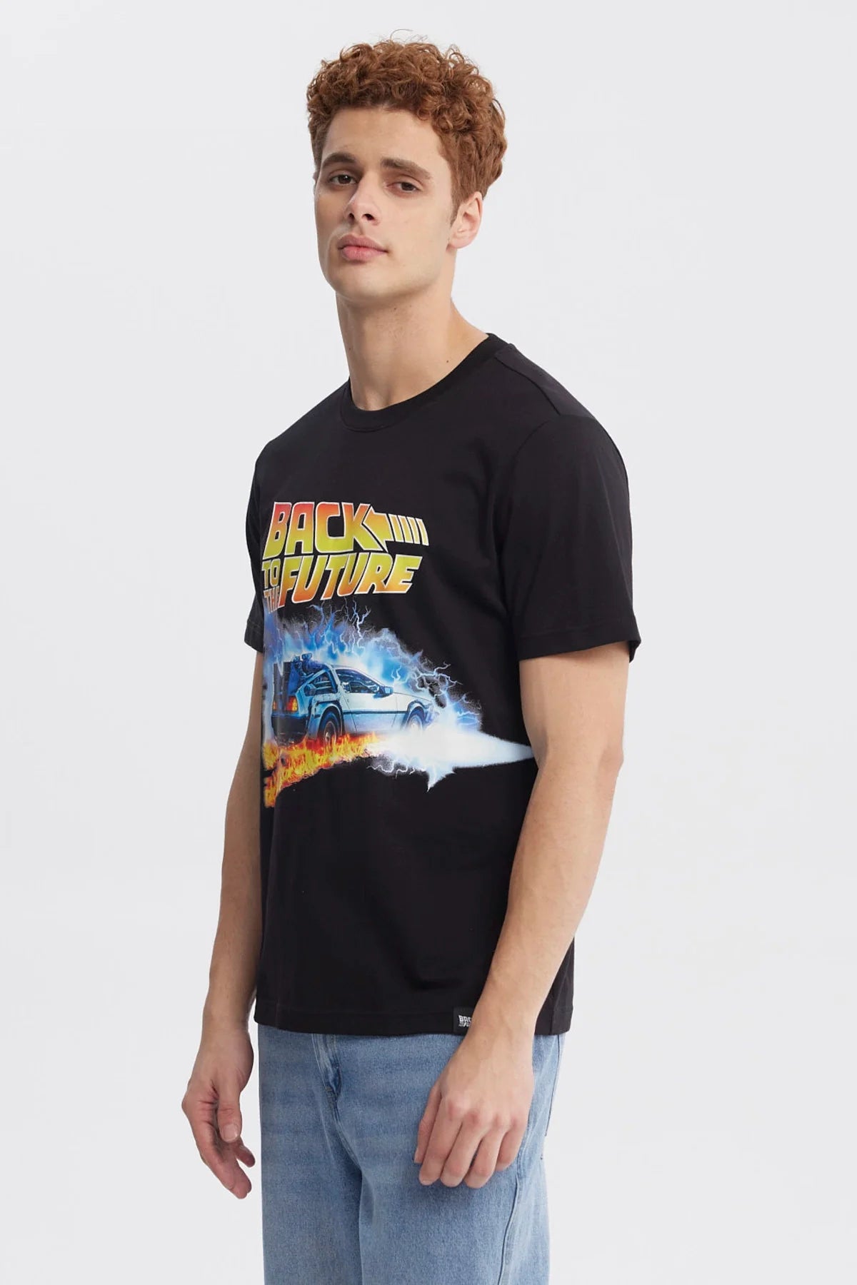 Polera negra de Back to the Future con un diseño vibrante que muestra el DeLorean rodeado de llamas y rayos, evocando la icónica saga de viajes en el tiempo.