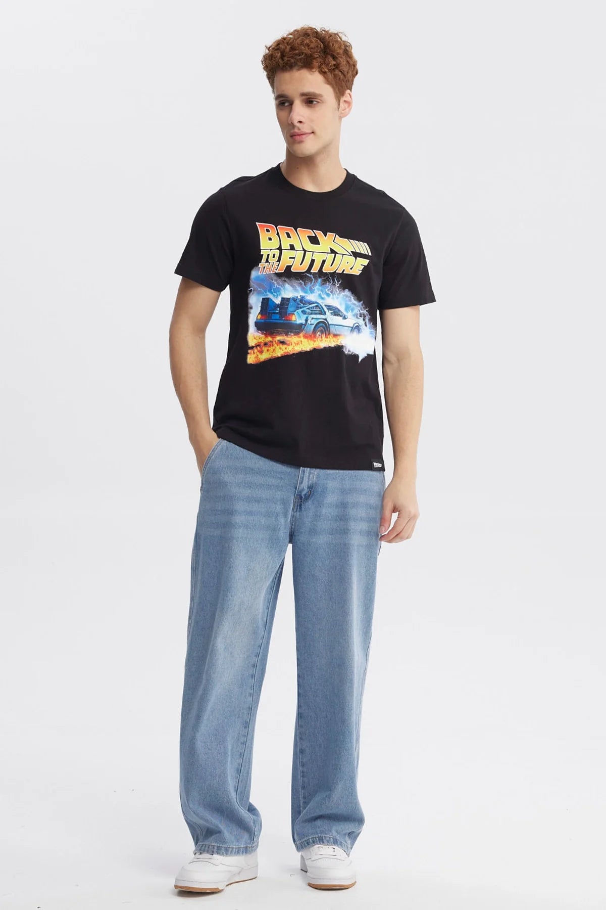 Polera negra de Back to the Future con un diseño vibrante que muestra el DeLorean rodeado de llamas y rayos, evocando la icónica saga de viajes en el tiempo.