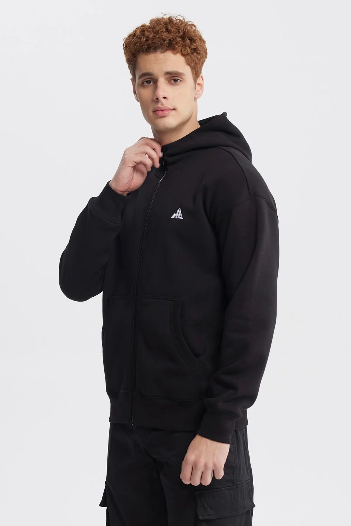 Polerón negro de Holly Concept con cierre frontal y capucha, presenta un logo minimalista en blanco en el pecho, ideal para los fans del estilo urbano.