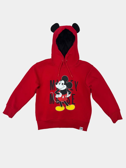 Polerón rojo con capucha de Mickey Mouse, presenta un diseño gráfico de Mickey en pose icónica, con orejas en la capucha y tipografía negra destacada.